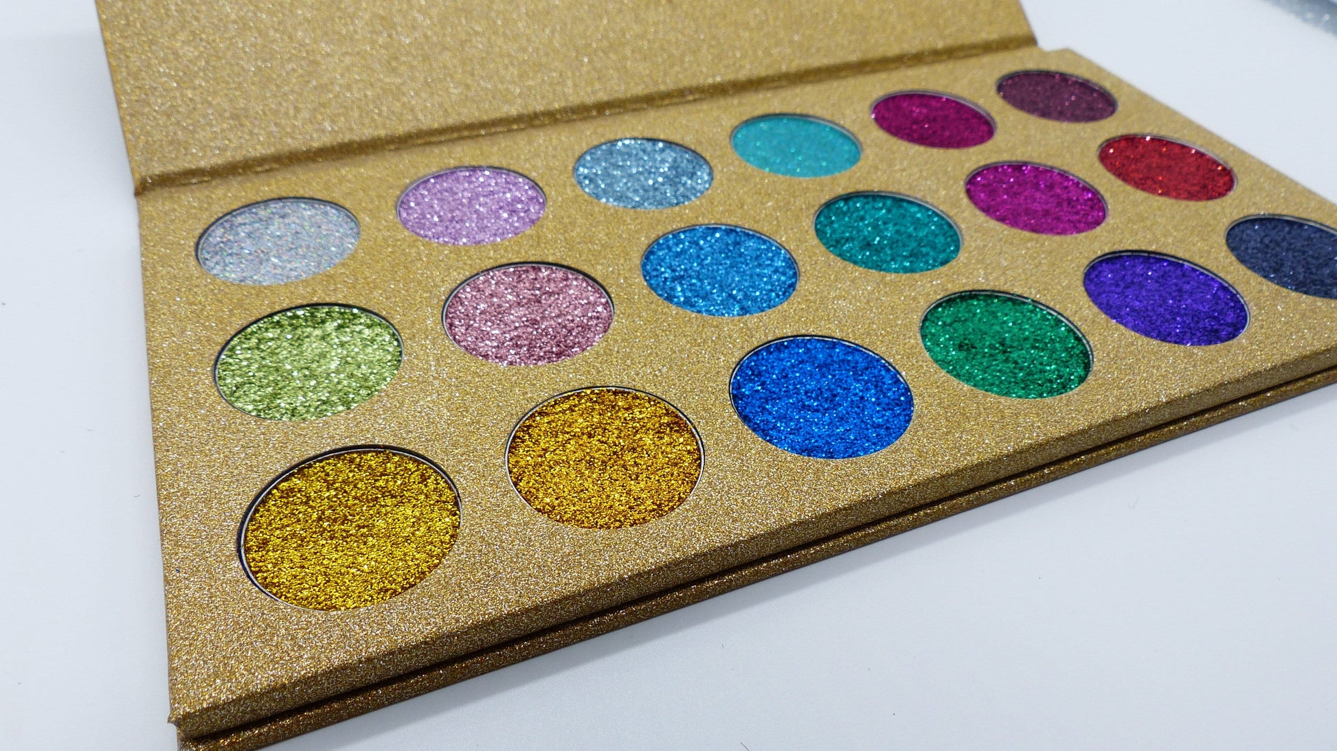 This palette has a gold exterior that shines brightly. This palette includes 18 colors. Some colors included are baby blue, blue, silver, light green, dark green, turquoise, gold, purple, and red. 